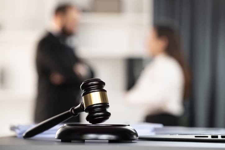 Focus closeup wooden gavel on blurred background of lawyer colleagues or legal team working at law firm office. Hammer of justice for righteous and equality judgment. Equilibrium